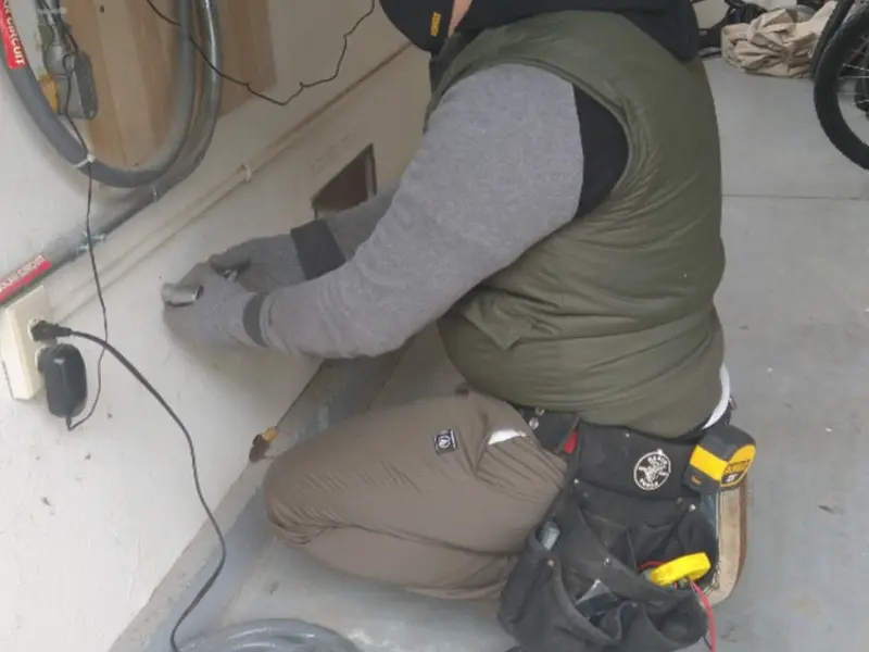 Electrician performing outlet wiring in a Eglin AFB garage
